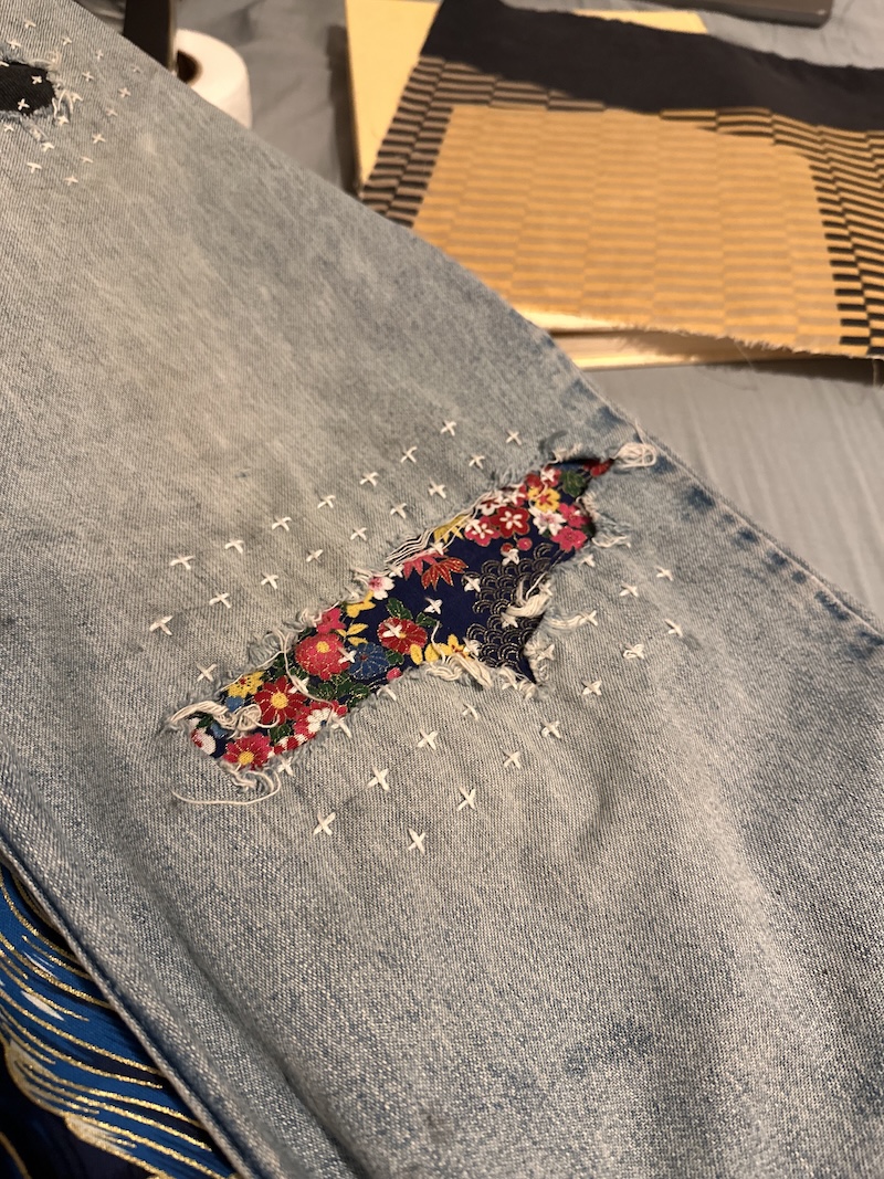 Plus-sign sashiko pattern over the repair